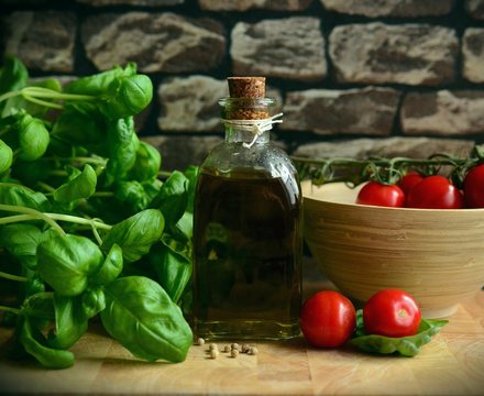 Basil, tomatoes and olive oil on a rustic table