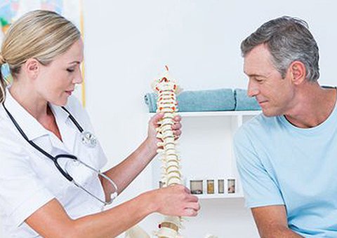 Physician explaining a spine model to a patient