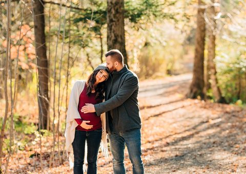 Expecting couple walking on an autumn forest path